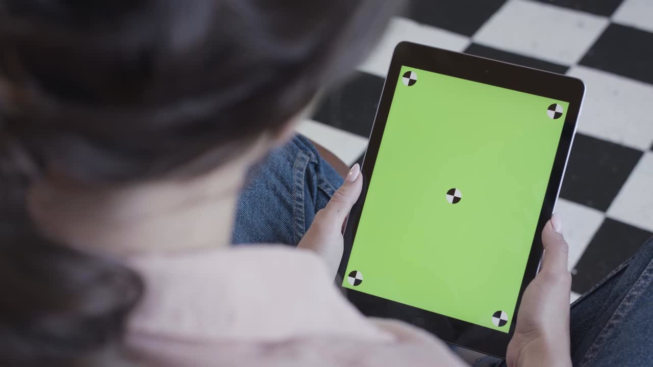 초록색 화면 을 가진 태블릿 을 들고 있는 여자