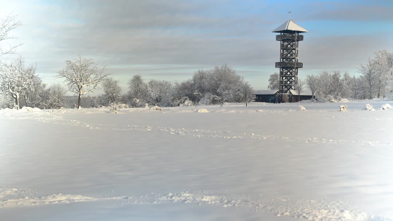 Timelapse of tourists visit medieval watchtower in snowy park in Belgium
