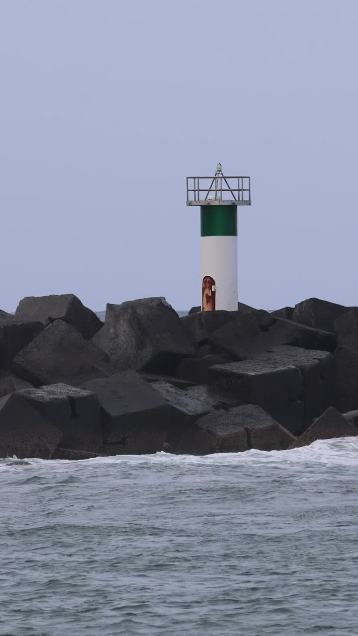 Sequenza di onde che si infrangono contro una barriera rocciosa costiera