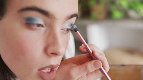 mujer transgénero caucásica no binaria haciendo maquillaje