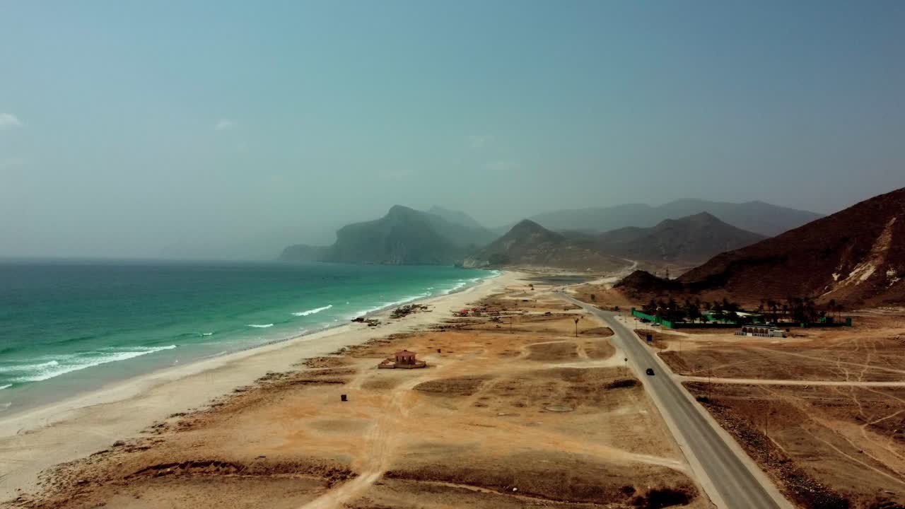 Stunning aerial views of Mughsail Beach, Oman! White sand, turquoise water, and dramatic cliffs await. Watch now!