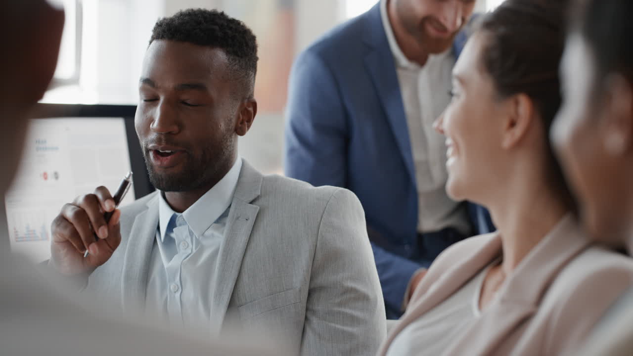 african american businessman chatting with colleagues in office meeting having conversation sharing ideas with diverse corporate group in workplace