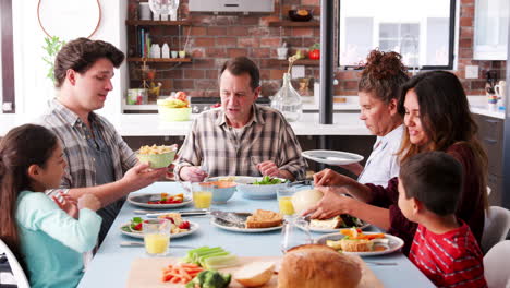 Familie-Mit-Mehreren-Generationen-Genießt-Das-Essen-Am-Tisch-Zu-Hause