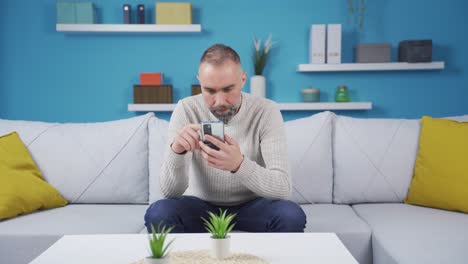 Ein-Einsamer-Mann,-Der-Aufs-Telefon-Schaut,-Wird-Emotional.