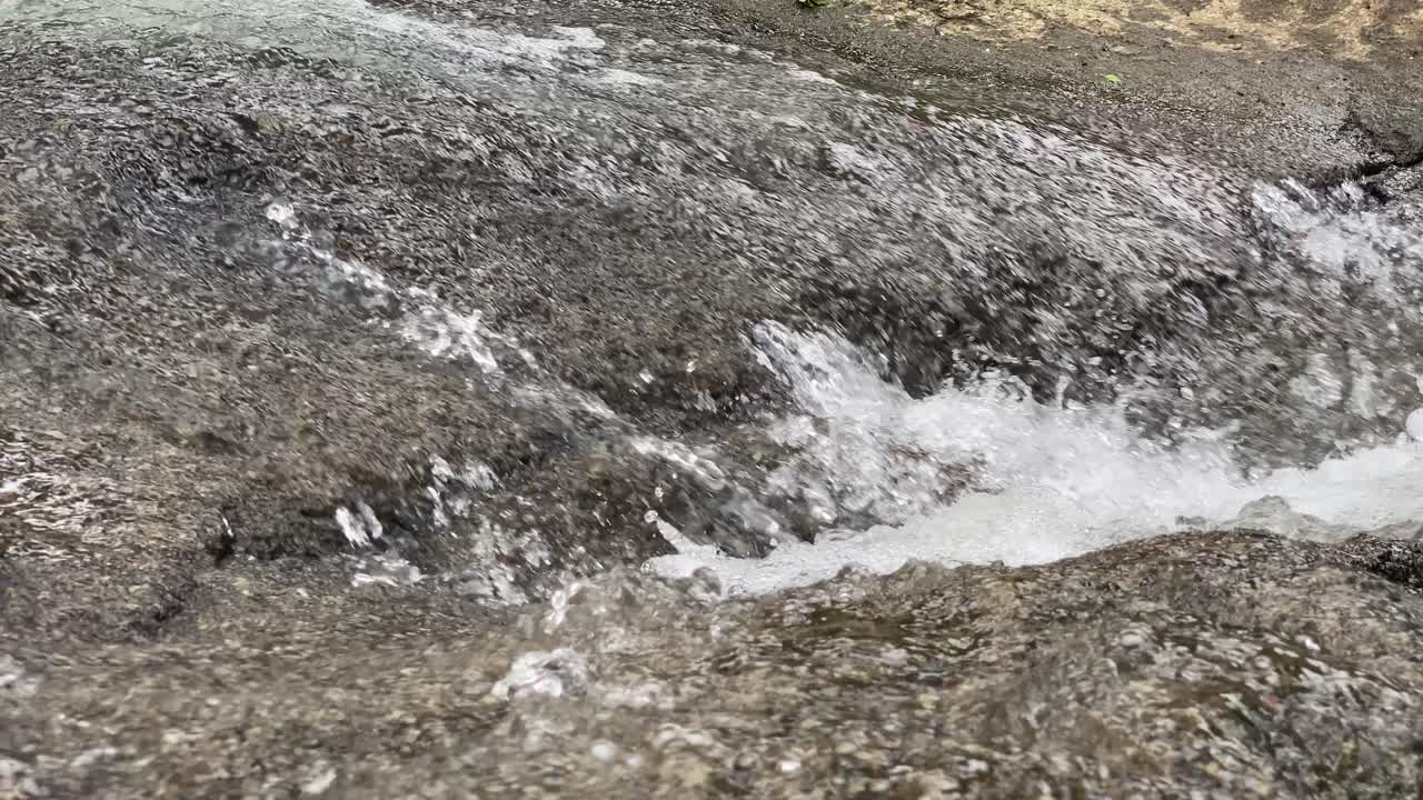 Primer plano del gorgoteo claro del río sobre las rocas.