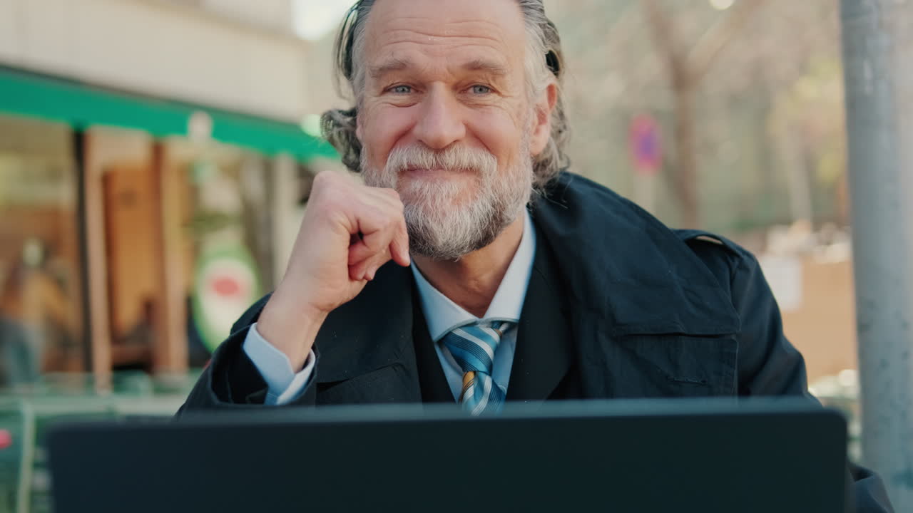 Geschäftsmann arbeitet an einem Laptop in einem Café im Freien