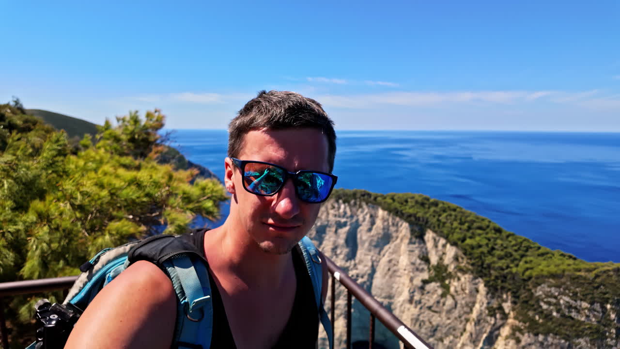 Man taking a selfie at a scenic coastal viewpoint overlooking the sea