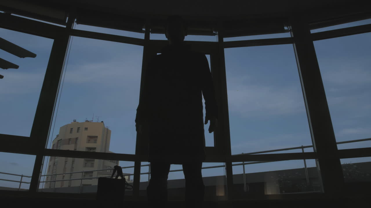 Persona junto a una ventana en un entorno urbano