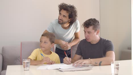 Two-dads-helping-son-with-school-home-task