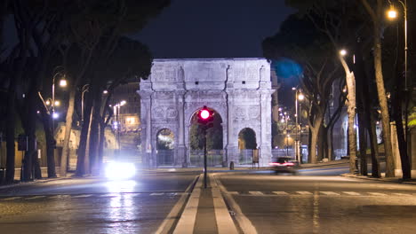 timelapse of road traffic in front of the arch of constantine in rome at night