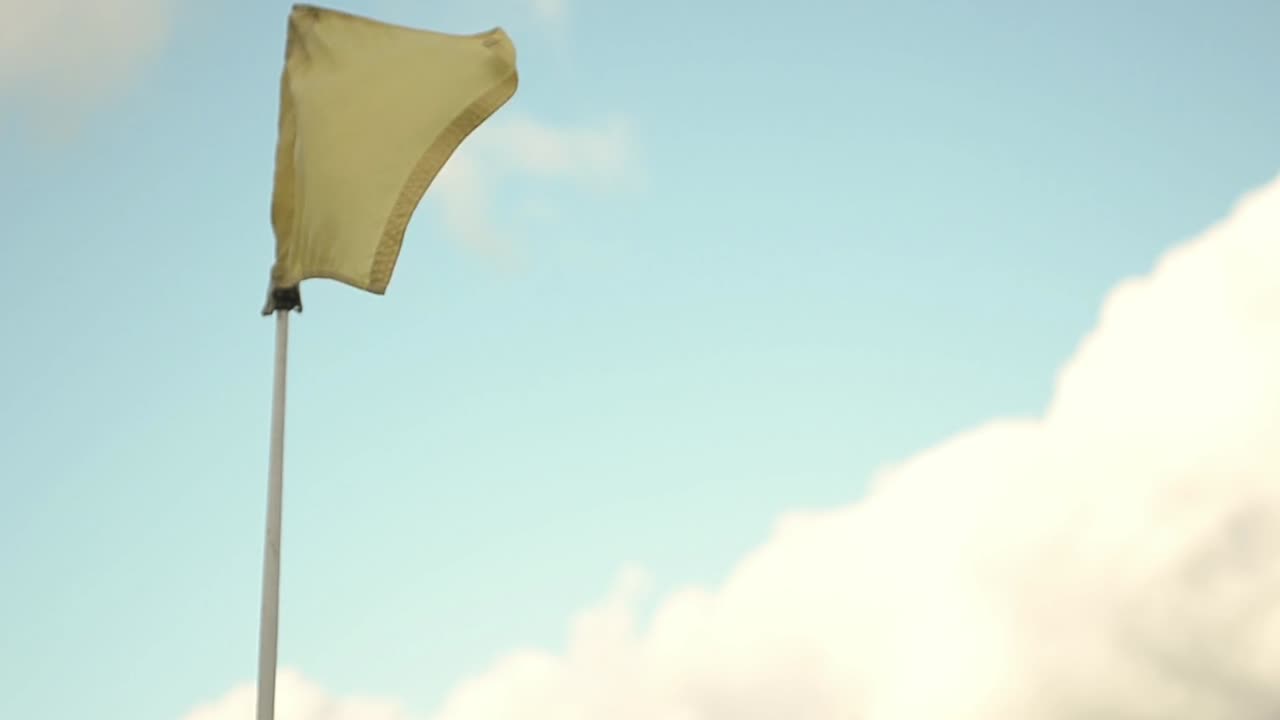 바람에 날리는 노란색 골프 깃발