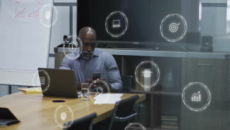 animation of digital icons over african american businessman in office