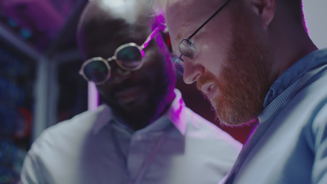 Mutliethnic Colleagues Working with Tablet in Data Center