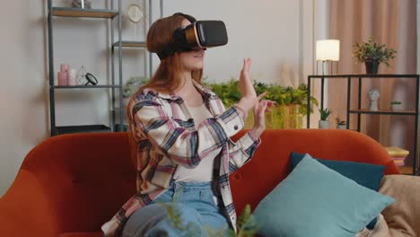 young girl use virtual reality headset glasses at home play 3d video game making gestures with hands