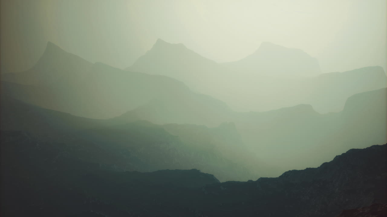 Majestic mountain ranges shrouded in mist during early morning hours