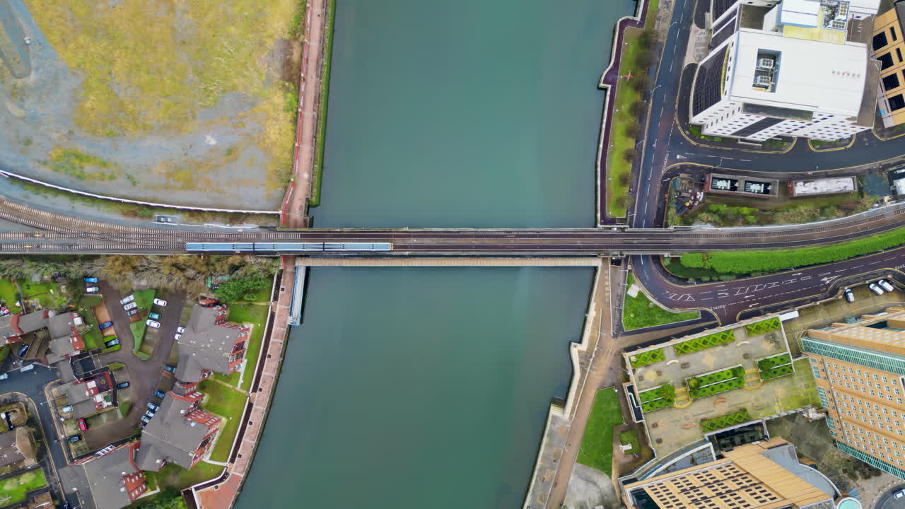 Aerial drone view of a train moving over the Belfast Railway Bridge above River Lagan in Belfast, Northern Ireland