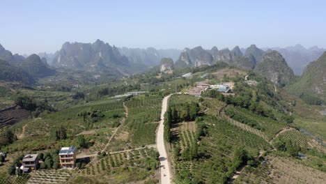 wide aerial shot of a farmland surrounded by mountains in yangshuo, china