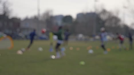 Schwarze-Männer-Trainieren-Fußball-Auf-Einem-Rasenfeld-In-Der-Sonne