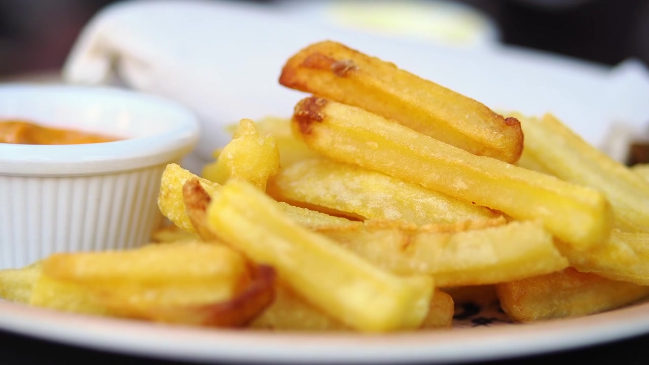 Close-up of Crispy Golden French Fries with Dipping Sauce