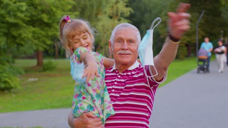 La-Cuarentena-Del-Coronavirus-Ha-Terminado,-El-Abuelo-Mayor-Con-El-Nieto-Quitándose-Las-Máscaras-Médicas-Celebra