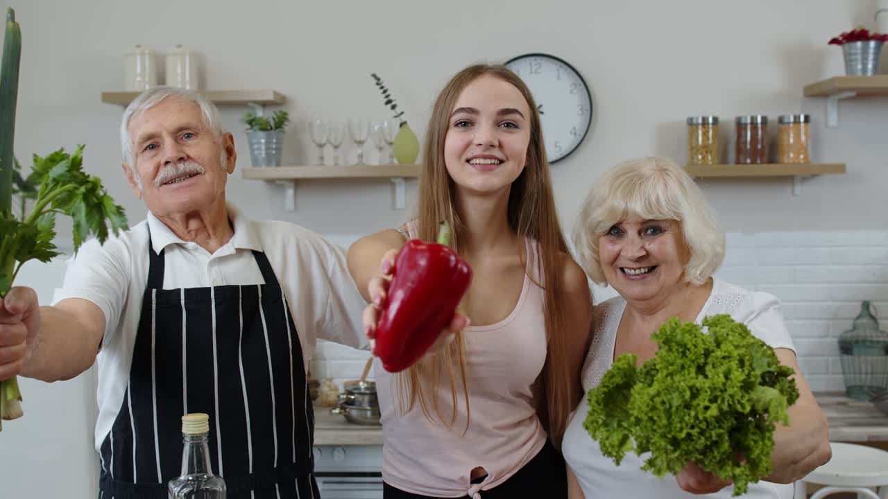 Wnuczka ze starszymi dziadkami polecająca jedzenie surowych warzyw. Dieta odżywcza.
