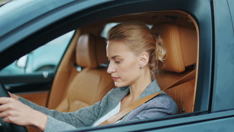 Closeup-woman-driver-buckling-seat-belt-at-car.-Woman-sitting-at-front-seat