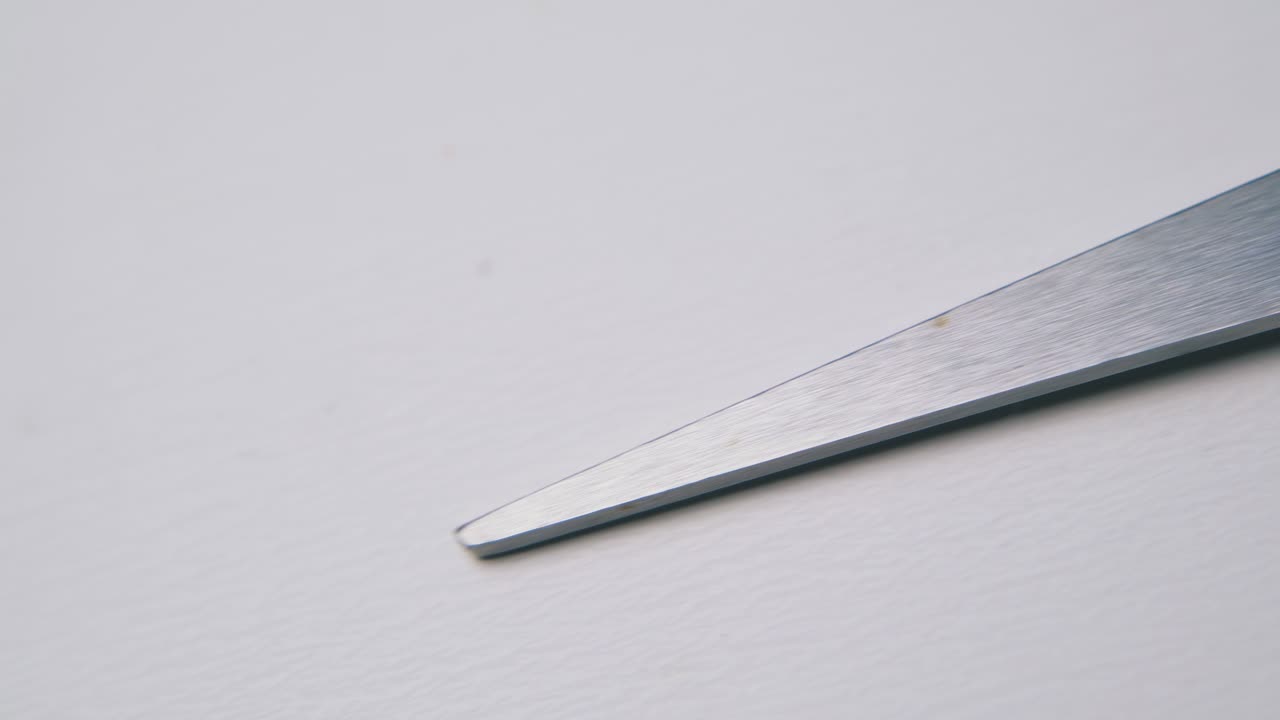 movimiento a lo largo de tijeras con asas negras en superficie blanca