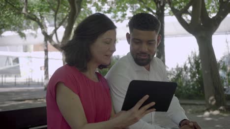 Feliz-Pareja-Multirracial-Usando-Tableta-En-El-Parque.