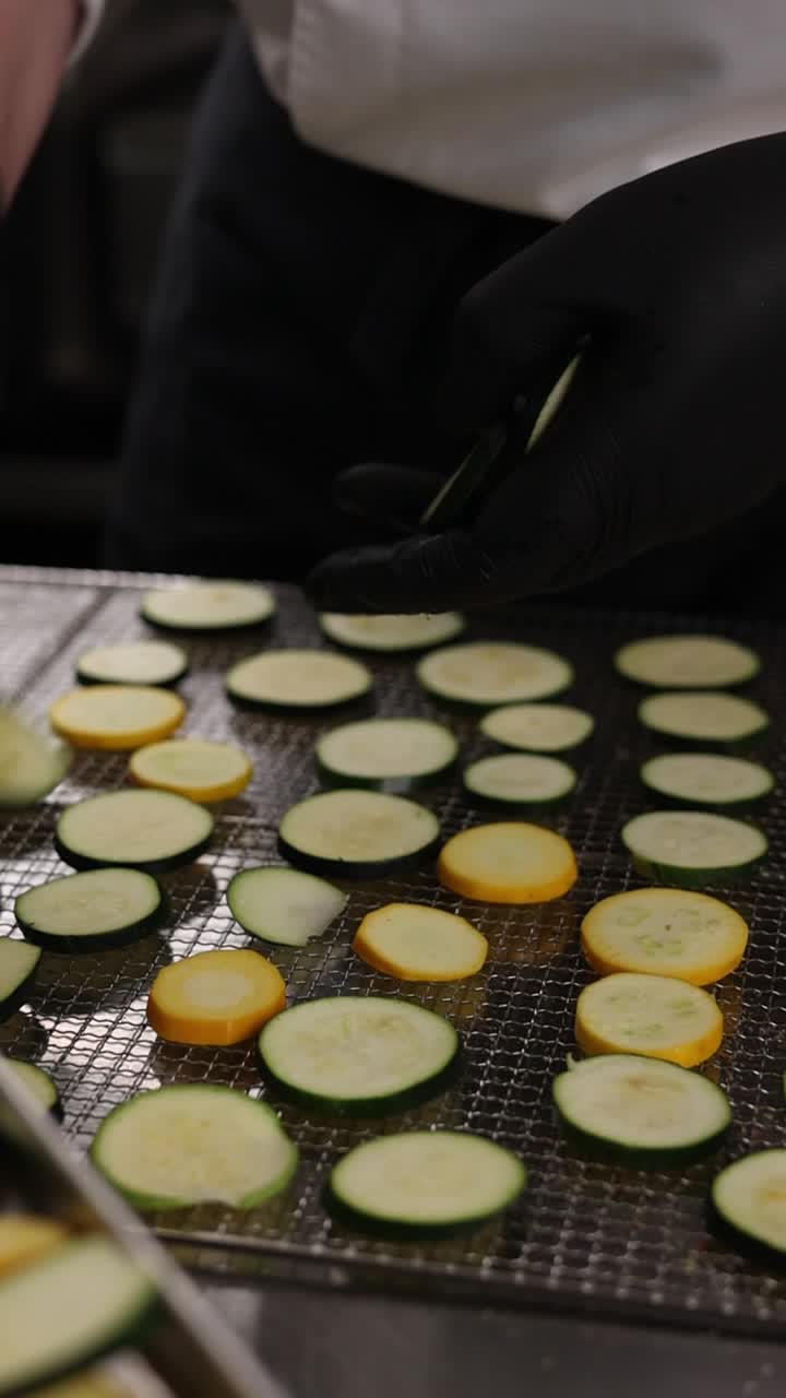 Chef preparing sliced zucchini for drying
