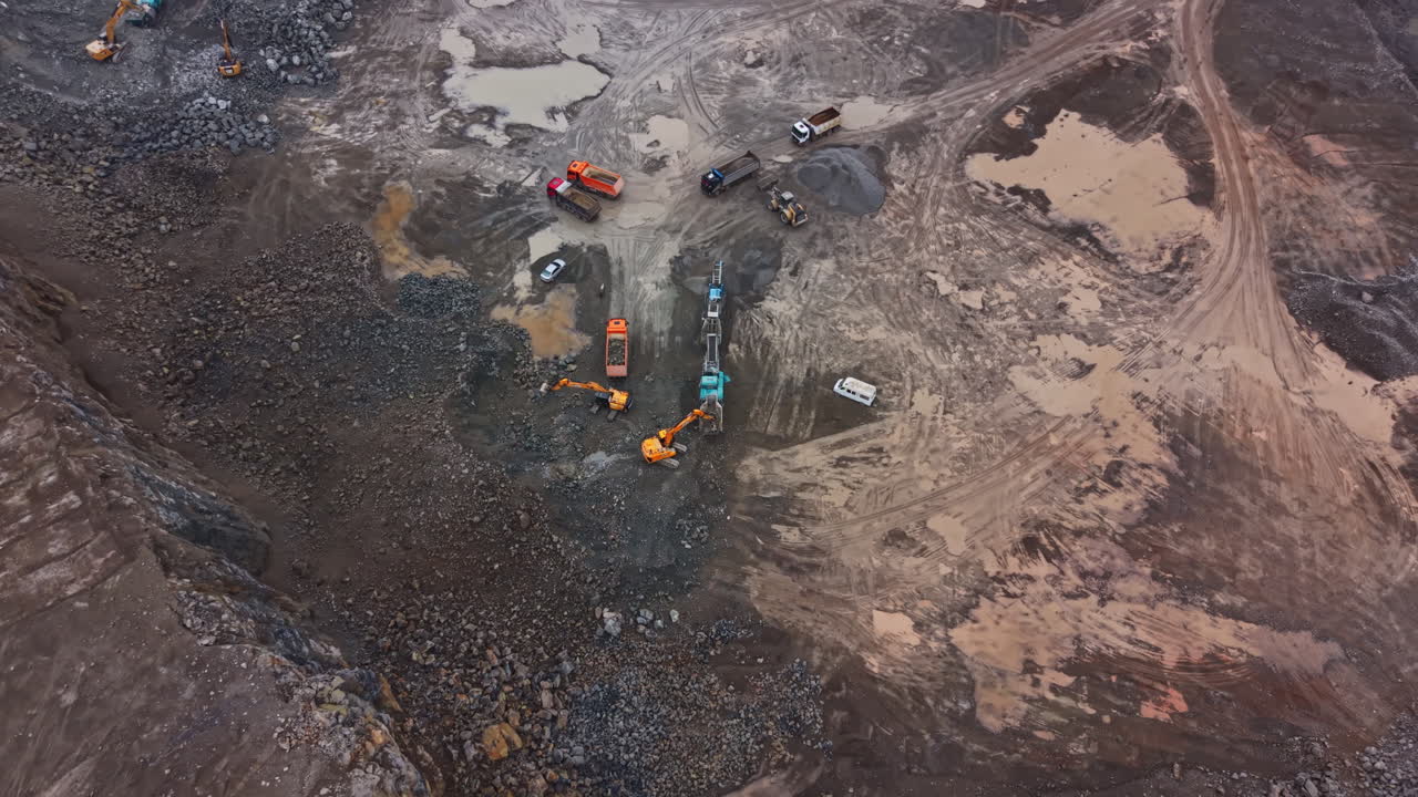 Heavy machinery works in granite quarry to extract rocks and minerals during the day in a remote location