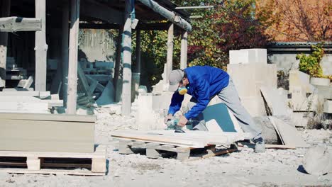 a man in a respirator polishes a stone with an electric angle grinder. sandstone art processing factory