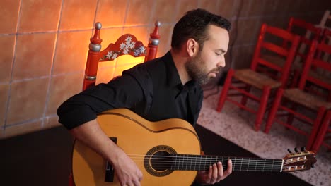 bearded man playing song on guitar