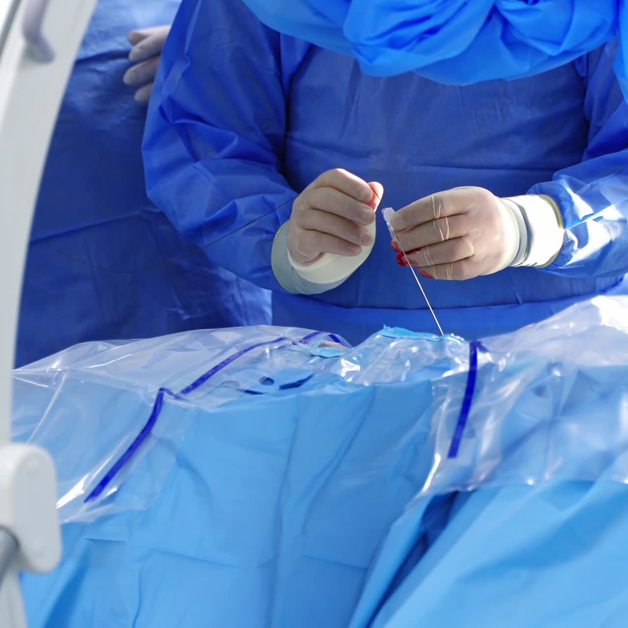 Surgeon's hands making the operation. Surgeon sews wound after surgery using surgical thread and needle. Doctor sutures during surgery