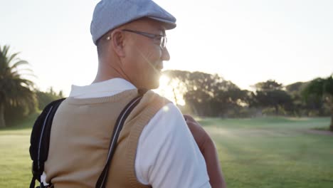 golfer carrying his golf bag