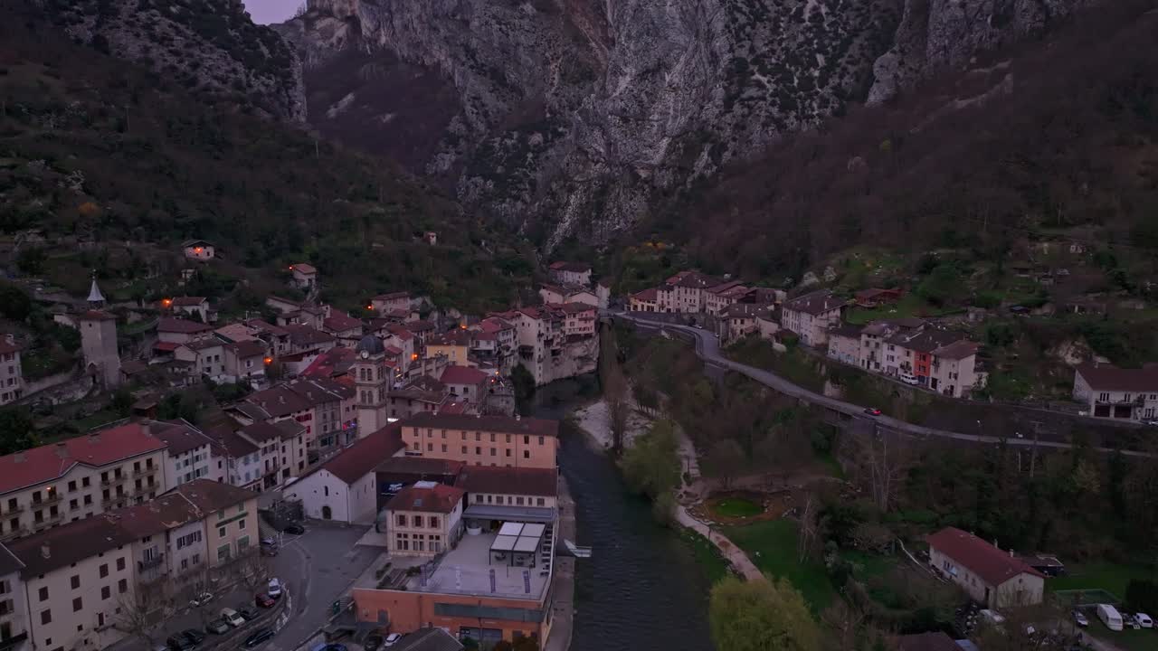 Bagliore del tramonto su case sospese aggrappate alla scogliera a Pont-en-Royans