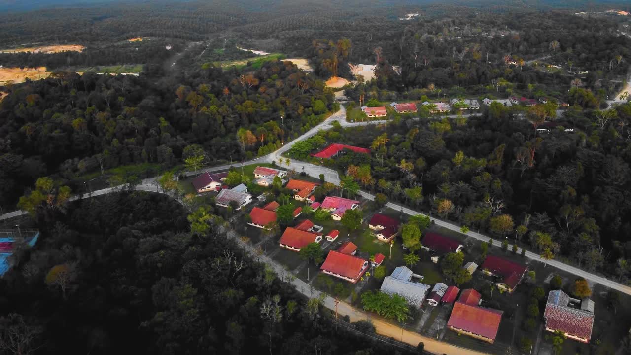 asombrosas imágenes cinematográficas de drones residenciales al atardecer de 4k después de que el problema de la deforestación consiste en casas, carreteras, árboles, lago e infraestructura en medio del bosque tropical ubicado en riau, indonesia