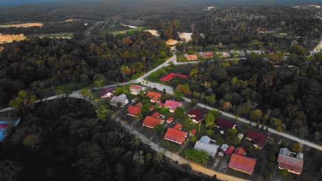 Amazing-cinematic-4K-sunset-residential-drone-footage-after-deforestation-issue-consists-of-homes,-road,-trees,-lake-and-infrastructure-in-the-middle-of-tropical-forest-located-in-Riau,-Indonesia