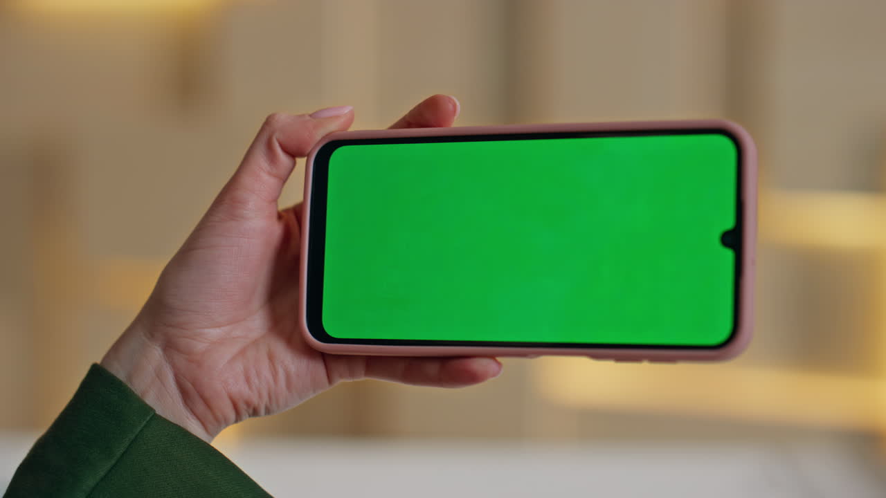 Unknown girl looking greenscreen cellphone in office closeup. Woman hand holding
