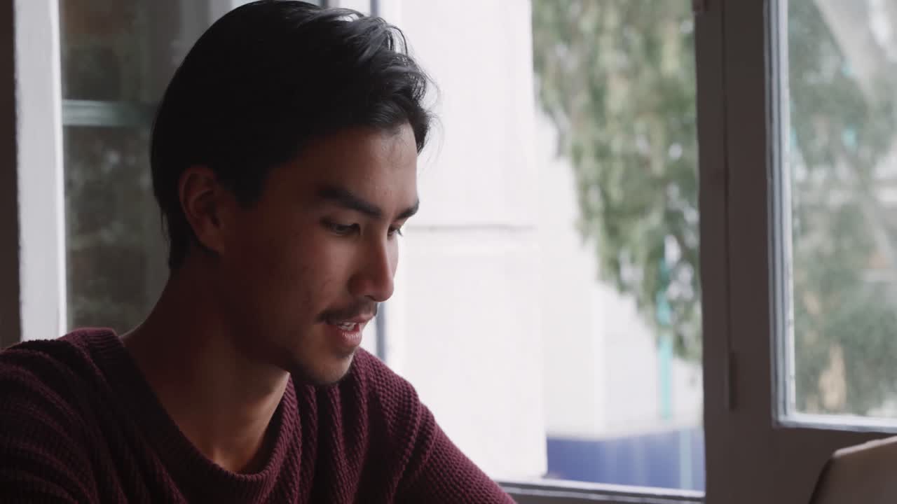 혼성 인종의 남자가 집에서 집중하고 일하고 있습니다.