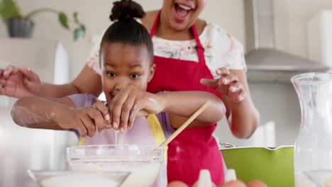 Feliz-Madre-E-Hija-Afroamericanas-Inalteradas-Horneando-En-La-Cocina,-En-Cámara-Lenta