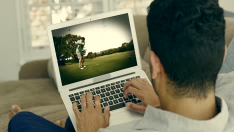 hombre viendo golf en el portátil en la sala de estar