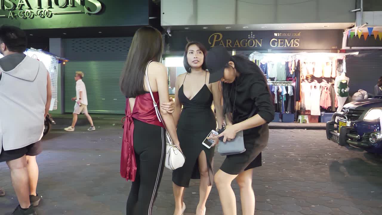 A group of three prostitutes in black dresses attract customers