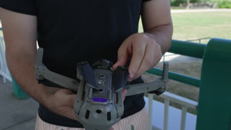 primer plano del hombre doblando las alas de un dron después del vuelo