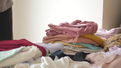clothes stacked in a bedroom