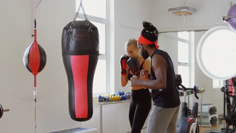 entrenador ayudando a una boxeadora en el estudio de fitness 4k