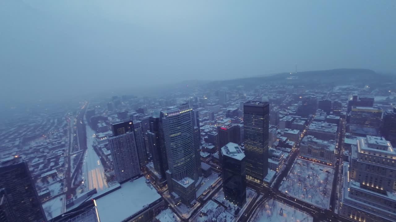 Beautiful aerial view of Montreal Downtown during winter morning, fog covered cityscape at Square Dorchester with snow and serene atmosphere, drone view.