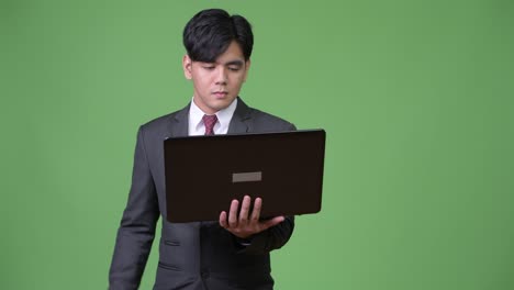 젊은 잘생긴 아시아 사업가 노트북을 사용