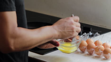 batir huevos en un recipiente de vidrio en el mostrador de la cocina cerca de la estufa en la cocina