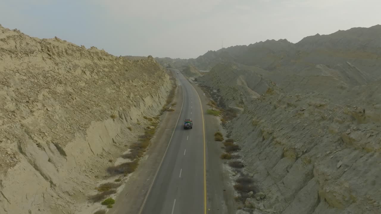Car driving on buzi pass top Makran coastal Highway Balochistan on sunny day drone footage