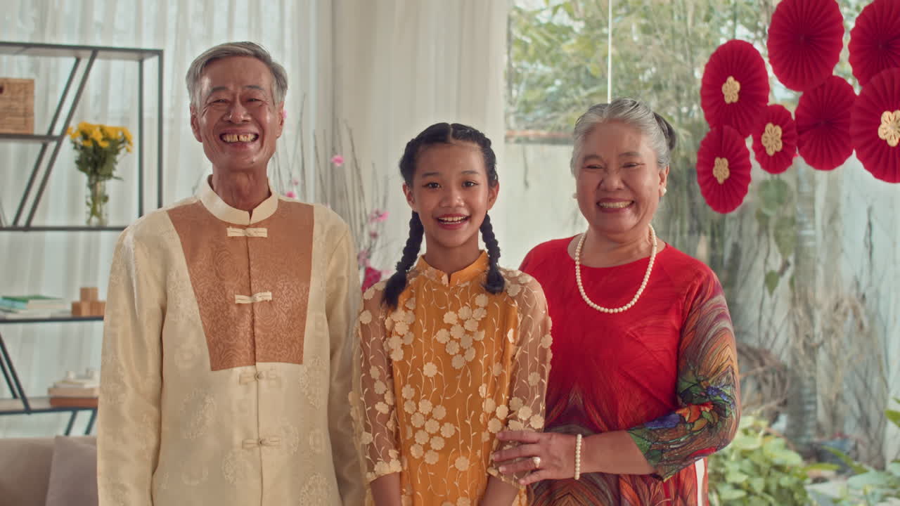 Portrait of Grandparents and Granddaughter Celebrating Tet at Home